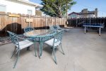 Back patio with ping-pong table, dining table, and lounge chairs.